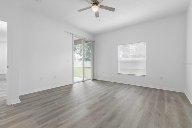 spare room with a ceiling fan, baseboards, and wood finished floors