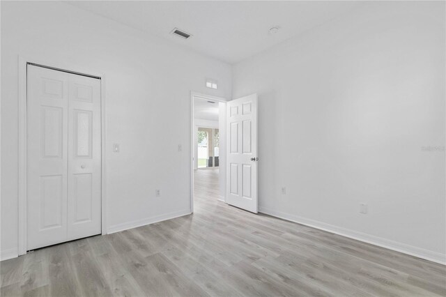 unfurnished bedroom with a closet and light hardwood / wood-style floors