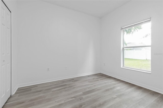 unfurnished room with light wood finished floors and baseboards