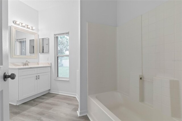 bathroom featuring tub / shower combination, hardwood / wood-style flooring, and vanity