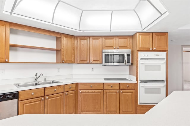 kitchen with brown cabinets, open shelves, stainless steel appliances, light countertops, and a sink