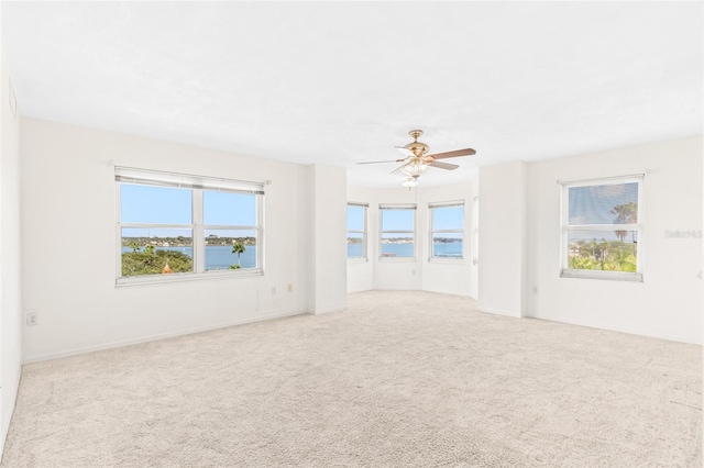 spare room with a ceiling fan, carpet, and a healthy amount of sunlight