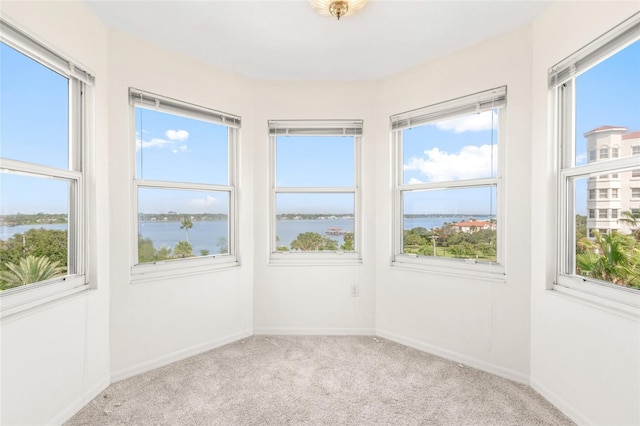 unfurnished sunroom featuring a water view