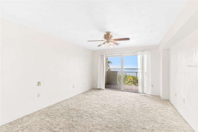 carpeted empty room featuring ceiling fan and baseboards