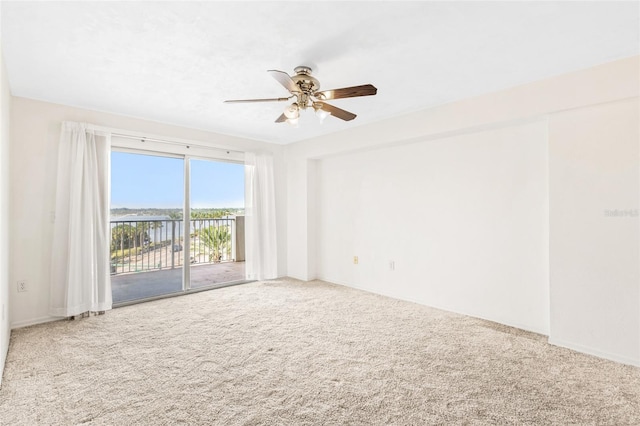 carpeted empty room with a ceiling fan