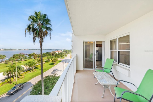 balcony featuring a water view and a sunroom