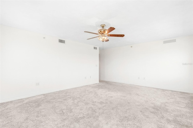 spare room featuring visible vents, ceiling fan, and carpet flooring