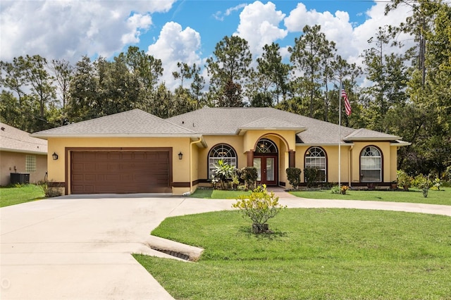 view of front facade with a front lawn, central AC, and a garage