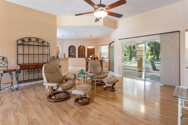 sitting room featuring light hardwood / wood-style floors and ceiling fan with notable chandelier