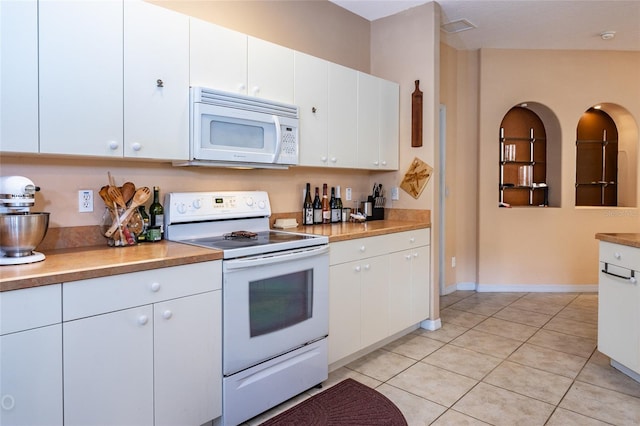 kitchen with light tile patterned floors, light countertops, visible vents, white cabinets, and white appliances