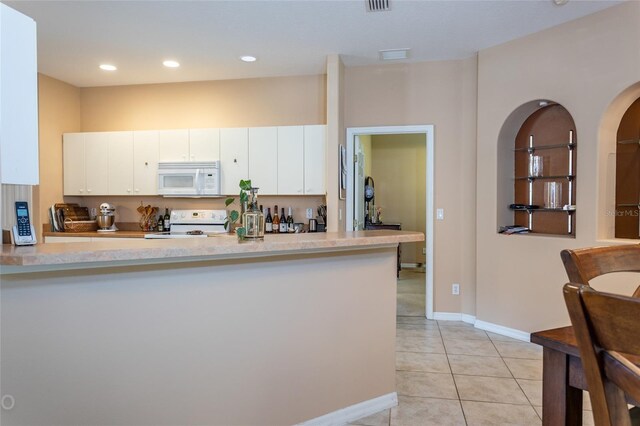 kitchen featuring kitchen peninsula, white cabinetry, white appliances, and light tile patterned floors