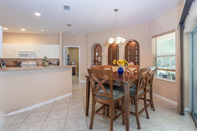 dining room with visible vents, arched walkways, baseboards, and light tile patterned flooring