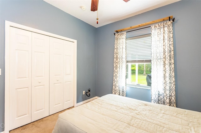 carpeted bedroom with ceiling fan and a closet