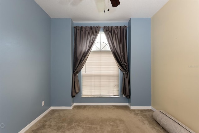 carpeted spare room featuring ceiling fan