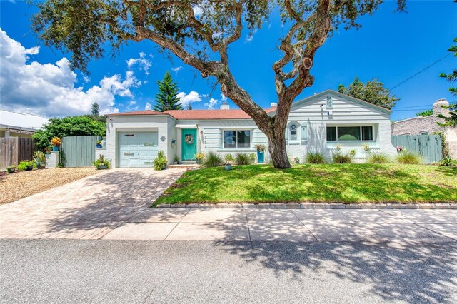 single story home with a front yard and a garage