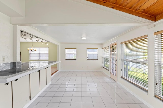 kitchen with white cabinetry, light tile patterned flooring, vaulted ceiling, and a notable chandelier