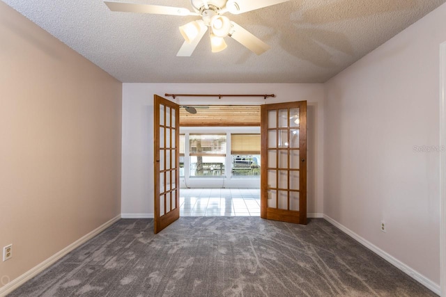 carpeted empty room with ceiling fan, french doors, and a textured ceiling