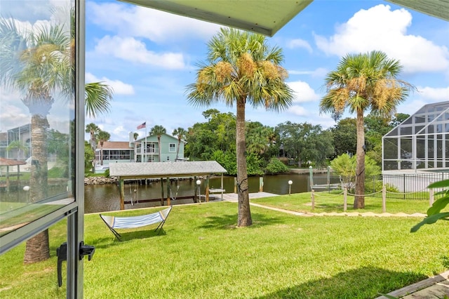 view of yard with a water view and glass enclosure