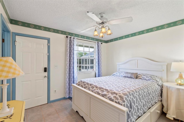 tiled bedroom featuring a textured ceiling and ceiling fan