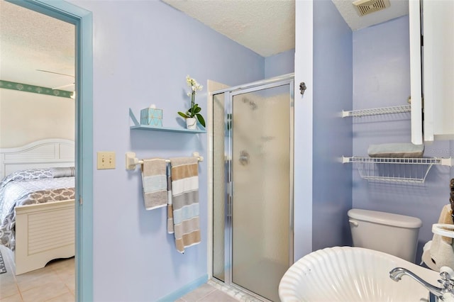 bathroom featuring tile patterned flooring, a shower with shower door, and a textured ceiling