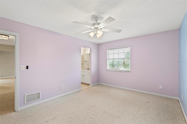 empty room featuring light carpet, a textured ceiling, and ceiling fan