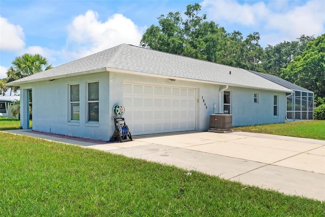 view of side of property with central air condition unit, a yard, and a garage