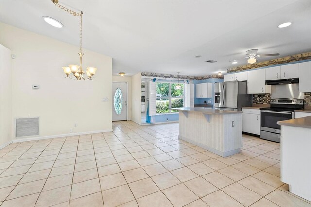 kitchen with appliances with stainless steel finishes, decorative light fixtures, backsplash, white cabinetry, and light tile patterned floors