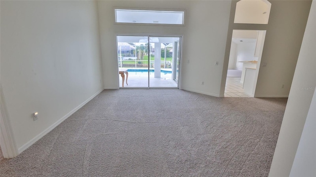 spare room with light colored carpet and a high ceiling