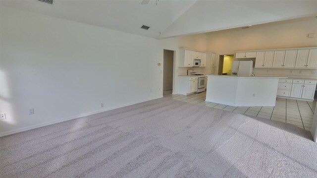 unfurnished living room with light carpet and high vaulted ceiling