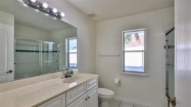 bathroom with tile patterned floors, a textured ceiling, vanity, toilet, and a shower with shower door