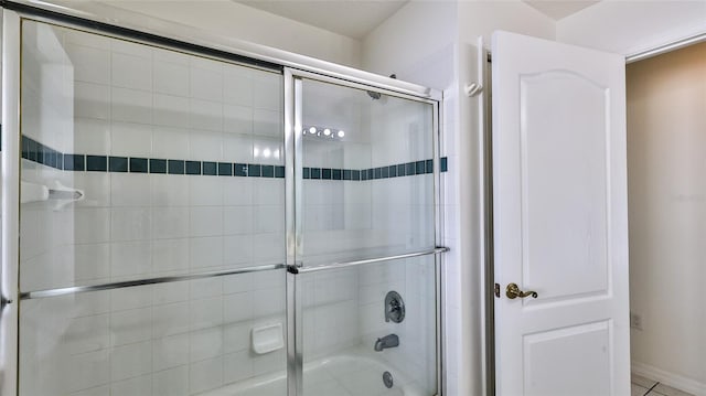 bathroom featuring tile patterned floors and bath / shower combo with glass door