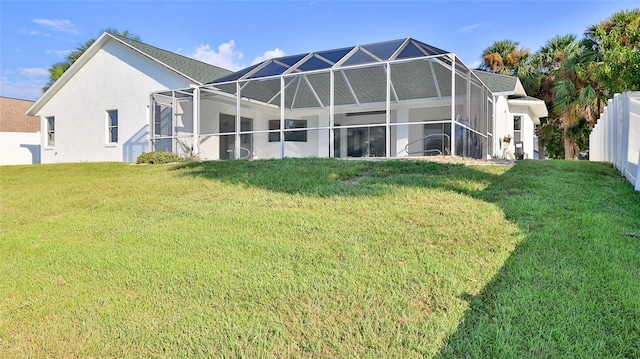 rear view of property featuring a lawn and a lanai