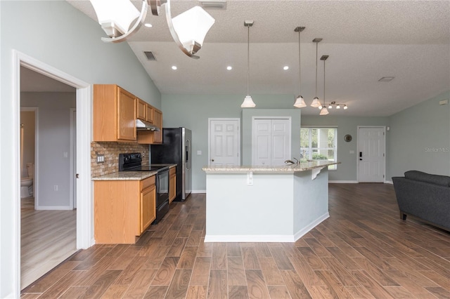 kitchen with hanging light fixtures, electric range, decorative backsplash, dark wood-type flooring, and under cabinet range hood