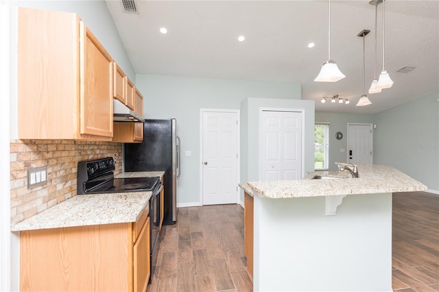 kitchen featuring dark wood-style flooring, black range with electric stovetop, a kitchen island with sink, under cabinet range hood, and pendant lighting