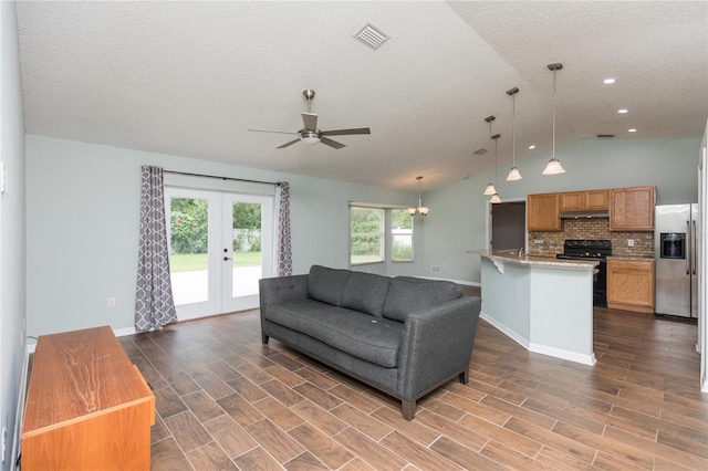 living area with vaulted ceiling, visible vents, wood finish floors, and french doors