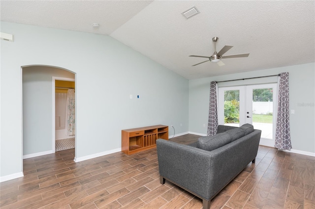 living room featuring arched walkways, visible vents, vaulted ceiling, and wood tiled floor