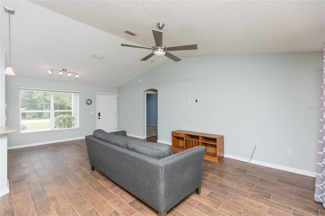 living room with visible vents, wood tiled floor, arched walkways, and a textured ceiling