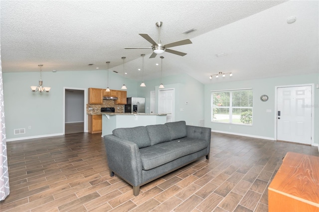 living area featuring wood tiled floor, visible vents, and ceiling fan with notable chandelier