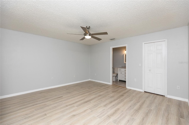 unfurnished bedroom featuring visible vents, light wood-style flooring, baseboards, and a textured ceiling