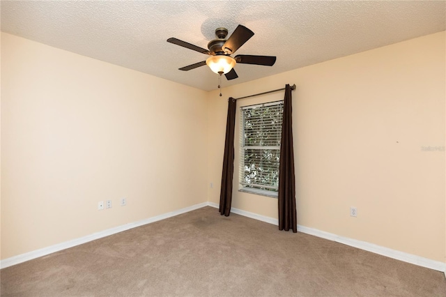 unfurnished room featuring ceiling fan, baseboards, a textured ceiling, and light colored carpet