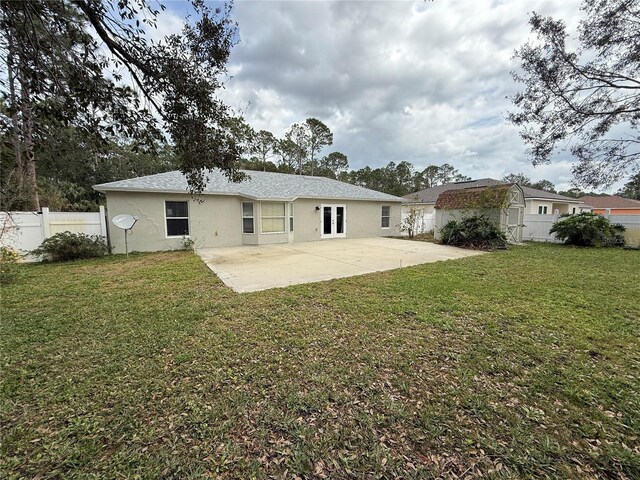 rear view of property with a patio area, a fenced backyard, a yard, and stucco siding