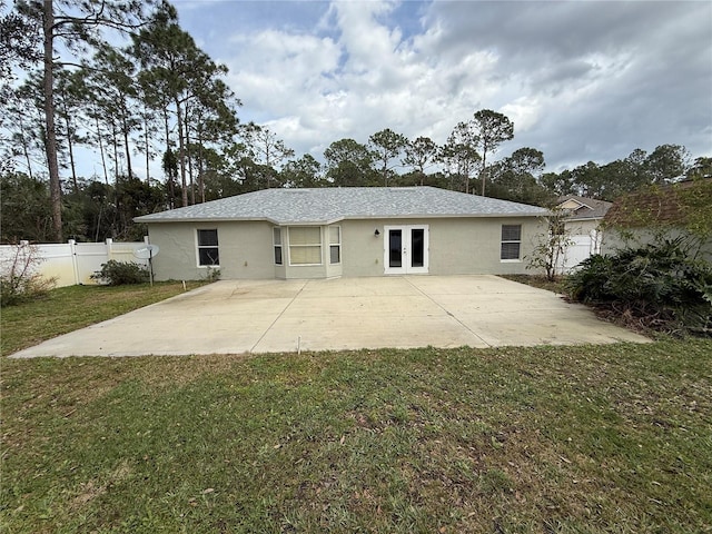 back of property with a patio, fence, french doors, a lawn, and stucco siding