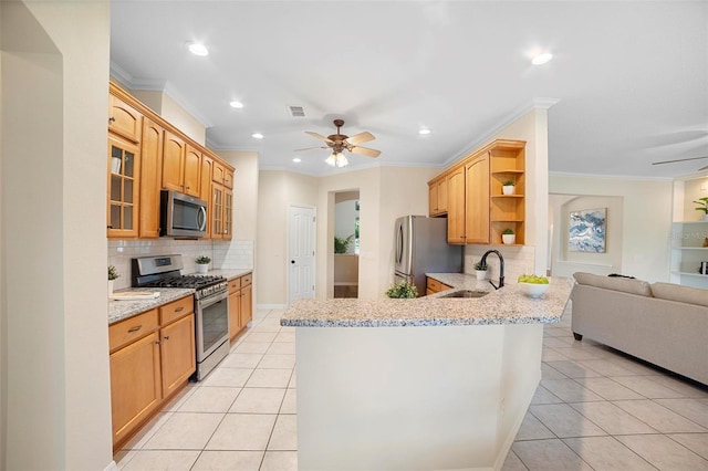 kitchen with sink, decorative backsplash, ornamental molding, appliances with stainless steel finishes, and kitchen peninsula