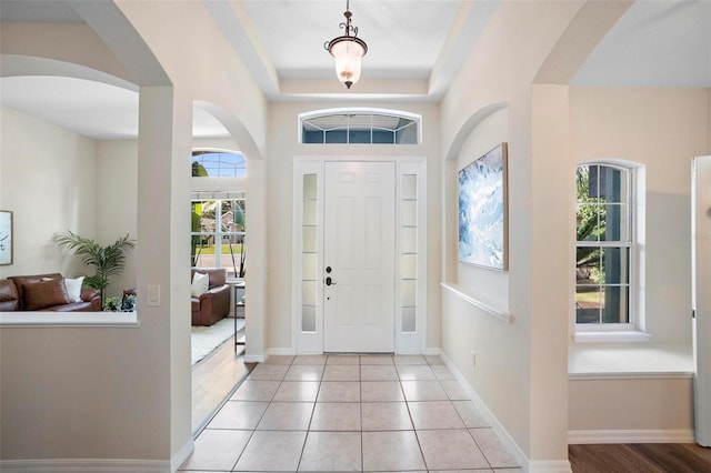 tiled foyer entrance featuring a raised ceiling