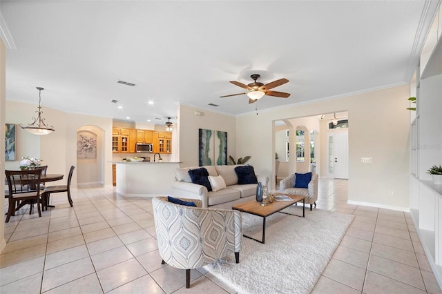 living room featuring ceiling fan, ornamental molding, and light tile patterned flooring