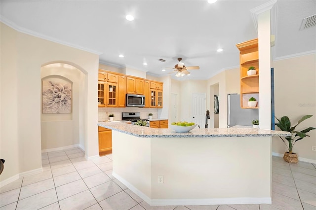 kitchen featuring light stone counters, light tile patterned flooring, stainless steel appliances, and ornamental molding