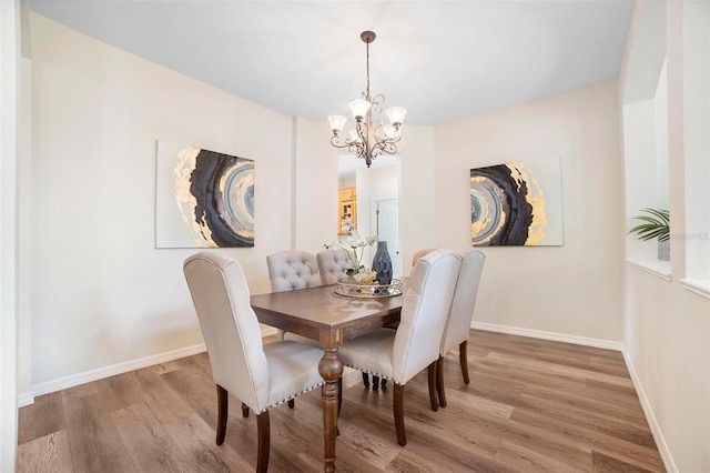 dining area with hardwood / wood-style floors and a notable chandelier