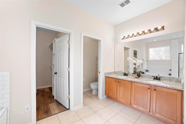 bathroom with tile patterned flooring, vanity, and toilet