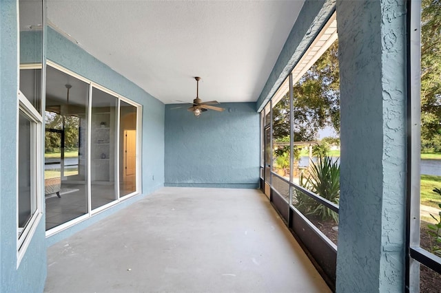 unfurnished sunroom with ceiling fan