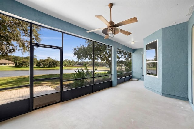 unfurnished sunroom featuring ceiling fan